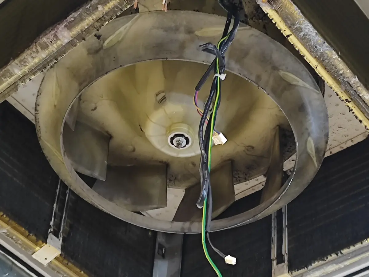 Ar-condicionado cassete aberto mostrando a turbina antes da higienização