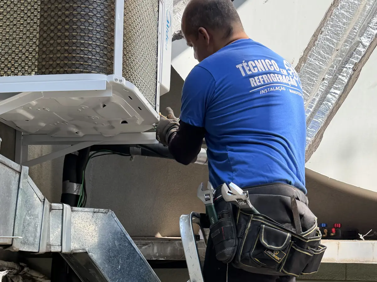Técnico da equipe realizando manutenção em unidade condensadora